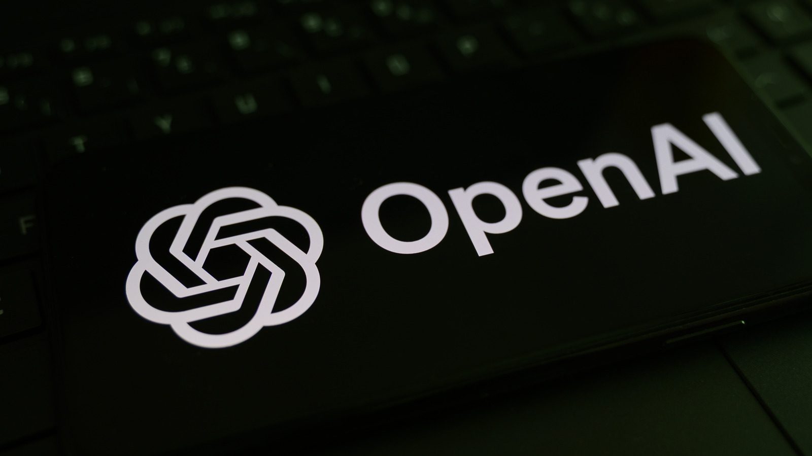 Le logo d'OpenAI affiché sur l'écran d'un smartphone posé sur un clavier